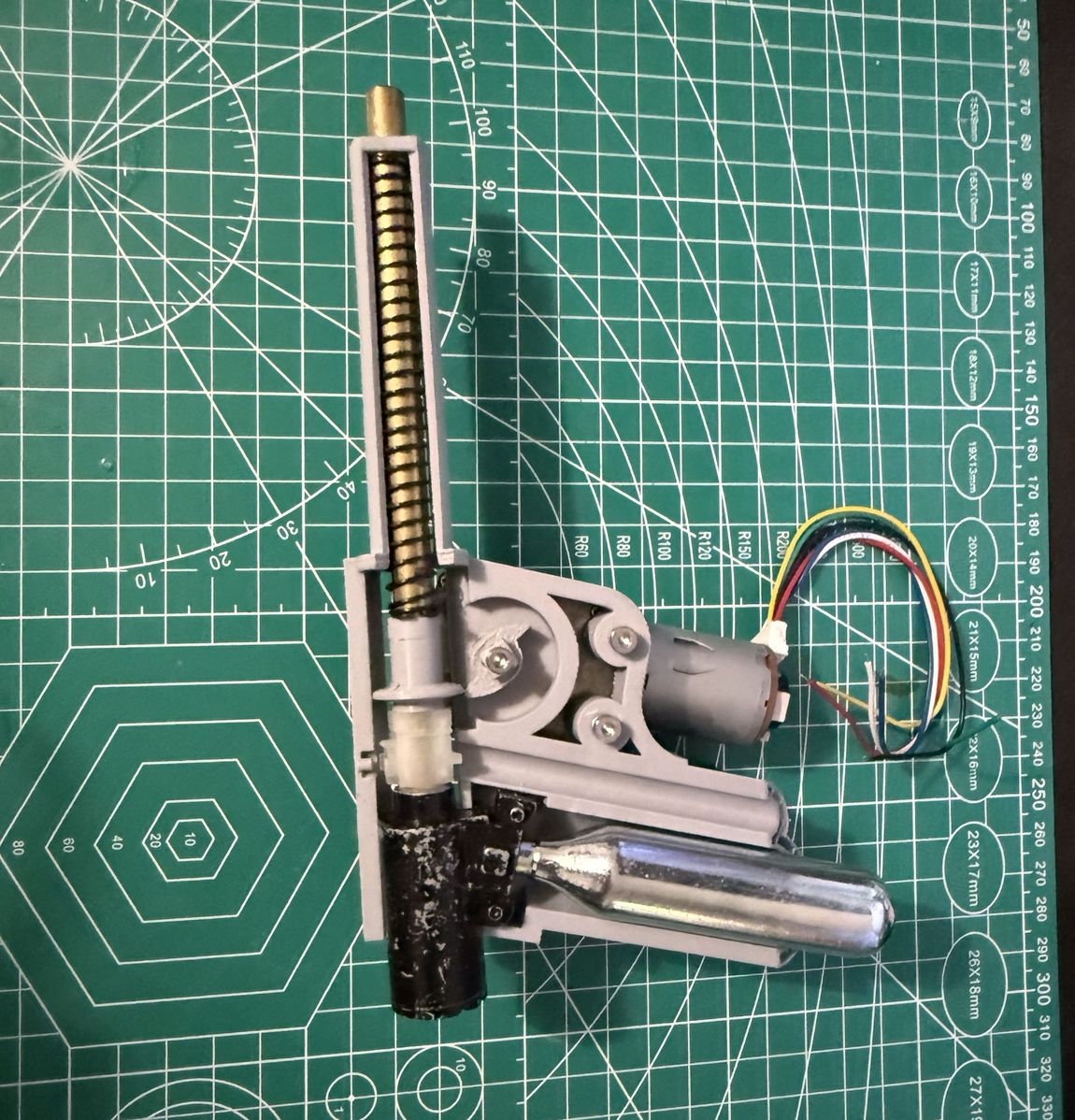 The first firing mechanism, printed almost as a single piece, with the brass barrel, drive spring, CO2 cartridge and gearmotor